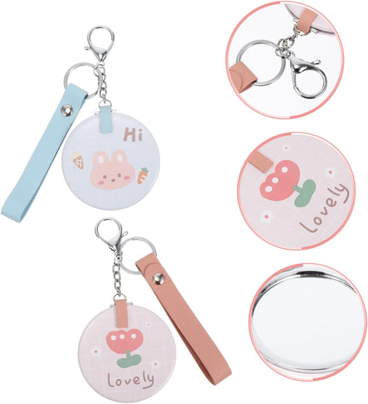 Wholesale mini round pocket mirrors. Metal folding flip - cover. Portable and cute for girls. Creative hand - held makeup touch - up small mirrors with lanyards.